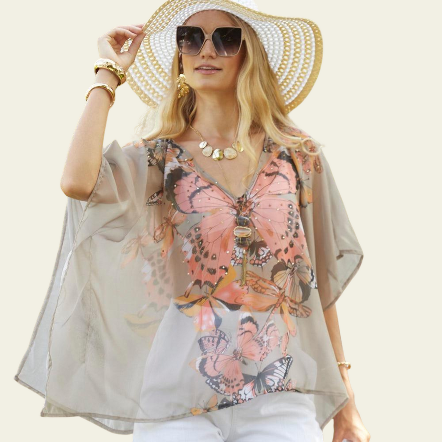 The Bijoux Terner Crystal Top Breathable Blouse is elegantly worn by the model, showcasing its lightweight fabric and graceful drape. The blouse flows effortlessly, highlighting its airy and breathable quality, perfect for warm weather. The design features a vibrant butterfly print in a mix of colorful hues, with shades of taupe that complement the intricate details of the butterflies.