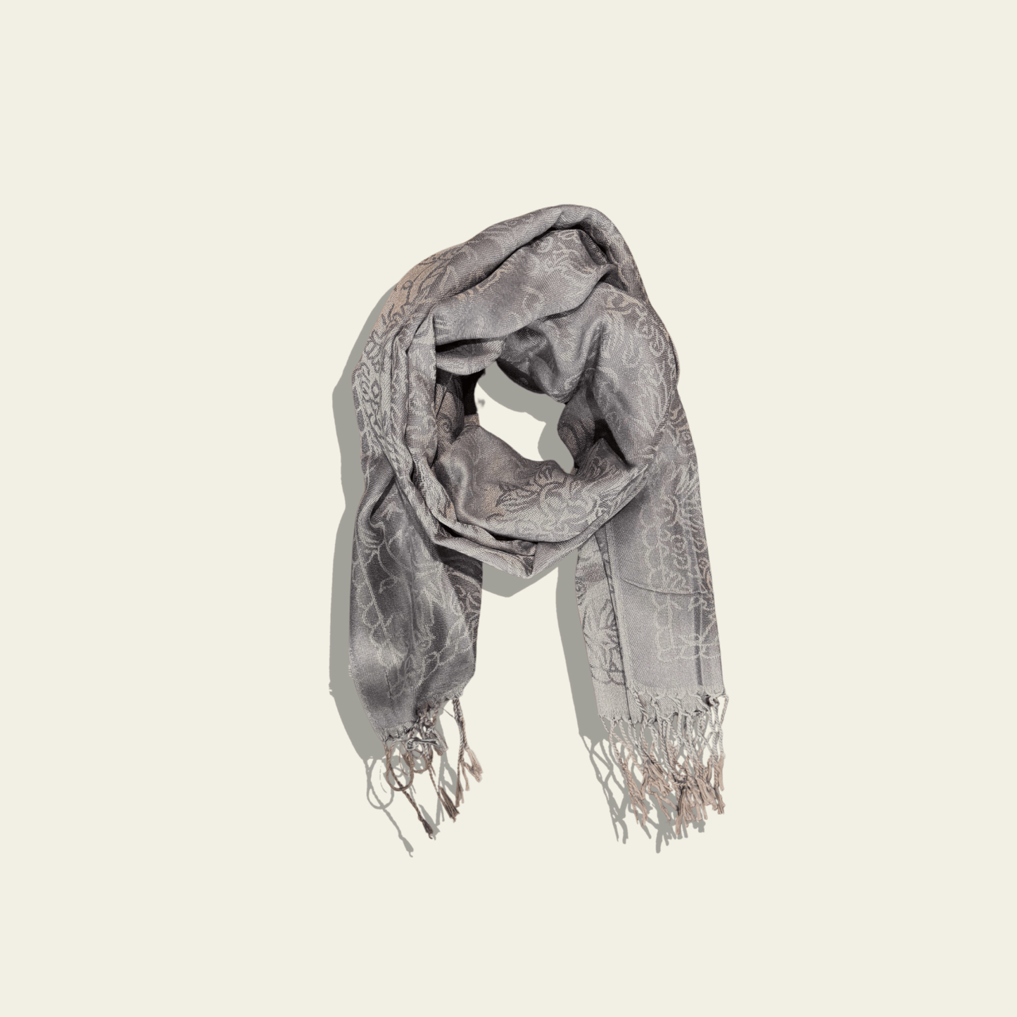 This luxurious grey jacquard shawl features intricate woven patterns, giving it a timeless, sophisticated appearance. The delicate weave and rich texture of the fabric are designed to stand the test of time, offering both warmth and style